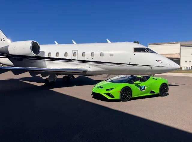 A green Lamborghini Huracán Spyder beside a private jet